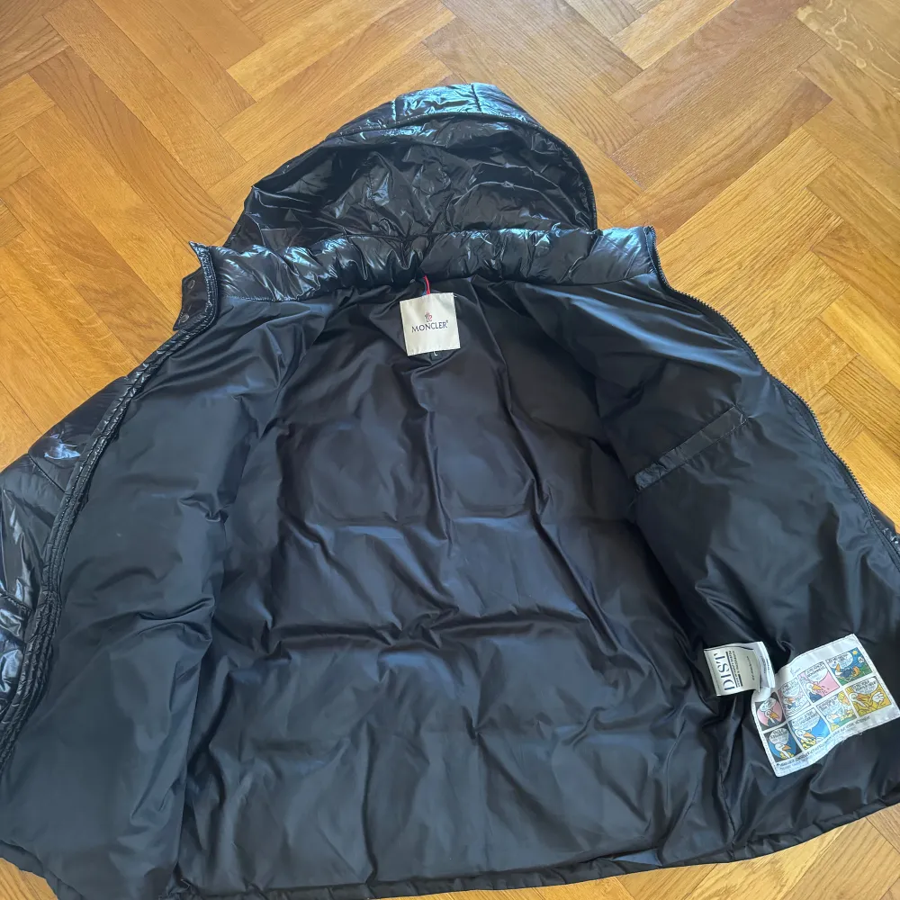 Säljer en snygg svart pufferjacka från Moncler med glansig yta och huva. Jackan har en dragkedja framtill och är perfekt för kyligare väder. Storlek L/M passar bra på båda. Hör gärna av dig om du har frågor 😁. Takit.