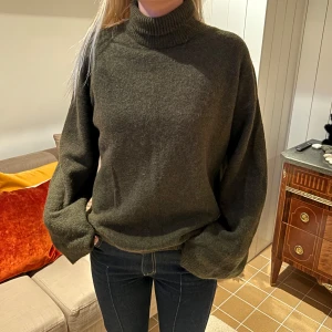 Olivgrön stickad polotröja - Säljer en mysig olivgrön stickad polotröja med långa ärmar. Från arket! Storlek S