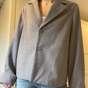 Grå kavaj från Object - Säljer en stilren grå kavaj från Object. Kavajen har en klassisk design med två knappar framtill och långa ärmar. Original pris: 1000kr. Perfekt för en casual outfit. Storlek 40 men passar som en M för mig som är en S vanligtvis. Du får dessutom jackan för 50% original pris