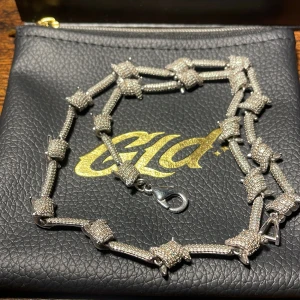 Halsband från GLD i 14k vitt guld pläterad 46cm långt - Snyggt halsband från GLD av pläterad 14k vitt guld med glittrande detaljer. Halsbandet har en unik design med taggtråds liknande länkar och ett praktiskt klolås. Halsbandet är i nästintill nyskick då det knappt är använt vilket syns. Org läder påse samt box för förvaring ingår. Nypris: ~ 3200kr | Mitt pris: 1500kr😁hör gärna av er vid frågor, pris ej hugget i sten 😊