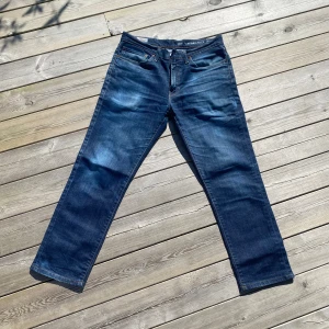 Levis 511 jeans - Snygga Levis 511 jeans i en klassisk blå färg. Sitter som 32/32 och de har en normal passform med en rak stil och är tillverkade i slitstarkt denim. Perfekta för en avslappnad look. Jeansens design inkluderar de ikoniska bakfickorna och en läderetikett med Levis logga.