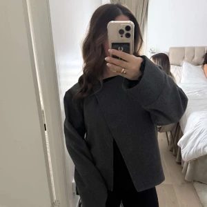 Grå kappa - Snygg grå kappa med en stilren design som är slutsåld på Gina Tricot. Jackan har långa ärmar och en enkel knäppning framtill. Perfekt för en elegant look. Materialet är perfekt nu till vår!💓 st M men passar er med S också!🌸 PSST: köpte kappan innan den sattes på rea!!