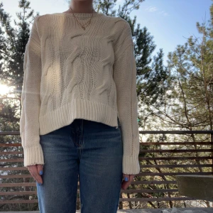 Beige stickad tröja VILA storlek S - Jättemysig vit beige stickad tröja från Vila i storlek S med ett snyggt flätmönster. Tröjan har långa ärmar och en ribbad kant vid ärmslut och nederkant. Använd ett fåtal gånger. Säljer då den tyvärr inte kommer till användning🥰