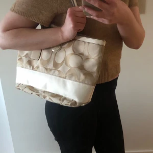 Äkta Coach väska  - Superfin äkta vintage Coachväska i beige canvas. Väldigt fint skick! Köpt på Vestiare Collective! Storlek medium. 