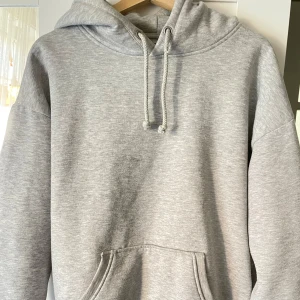 Hoodie Bikbok - Säljer en stilren grå hoodie från BikBok. Lite nopprig. Oversized passform. Den har en klassisk design med känguruficka och justerbar dragsko i huvan.
