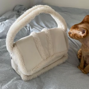 Vit fluffig handväska - Säljer en supermjuk och fluffig vit handväska. Den är rymlig nog för dina dagliga nödvändigheter. Katt med för storleksreferens lol;)