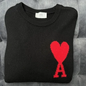 Svart tröja från Ami Alexandre Mattiussi - Säljer en stilren svart tröja från Ami Alexandre Mattiussi med ett stort rött hjärta och bokstaven A på bröstet. Perfekt för en trendig look! Helt fräsch! Knappt använd! Skick är nytt, säljs pågrund av inte min smak av stil! Passar M/S Skriv gärna för mer bilder / frågor ! 💗 (pris går att diskuteras vid smidig och snabb affär) 