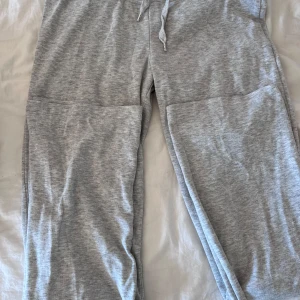 Grå mjukisbyxor från Gina Tricot - Säljer ett par bekväma grå mjukisbyxor från Gina Tricot. Byxorna har en dragsko i midjan för justerbar passform. Använda max 5 ggr