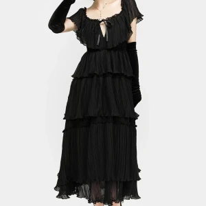 Svart klänning från Disturbia - Säljer en elegant svart klänning från Disturbia med volanger och knytning framtill. Klänningen har korta ärmar och en flerdelad design som ger en vacker siluett. Perfekt för en stilfull kväll.