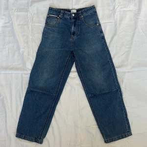 Blå jeans från Eytys - Snygga blå jeans från Eytys i modellen Titan Stone Indigo. De har en klassisk femficksdesign och en rak passform. Perfekta för en avslappnad stil. Märkesdetaljer syns på knappen och etiketten. Köpta på Vallgatan 12! Nypris 2800kr