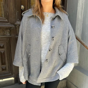 Grå trekvartsärmad poncho  - En snygg trekvartsärmad poncho med snygga knappar framtill💕
