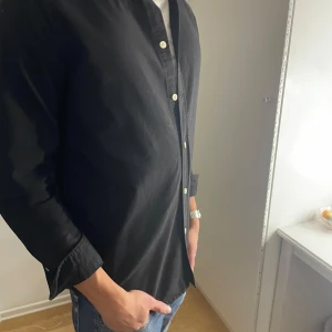 Svart skjorta från Samsøe Samsøe - Schysst svart bomullsskjorta från Samsøe. Plagget är använt men tagit hand om med skötsamhet. Skick 8/10, passar stl S. Tveka inte att höra av dig vid frågor eller funderingar.