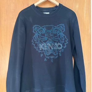 Kenzo långärmad tröja - En svart sweatshirt med turkos logga från kenzo. Använd ett fåtal gånger, sedan har den bara samlat damm. Nypris 1800.