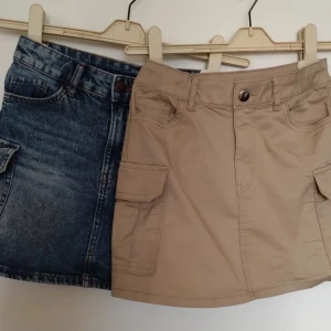 Två kjolar i beige och blå - Jag säljer två snygga kjolar, en i beige och den andra i jeans material (blå)💗storlek 134-140 men känns absolut inte som det, mer som XS.
