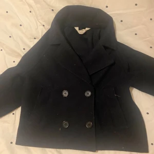 Svart kappa med knappar! 💞 - Säljer en stilren svart kappa med dubbelknäppning och bred krage. Jackan har långa ärmar och är perfekt för kyligare dagar. 🧥❣️