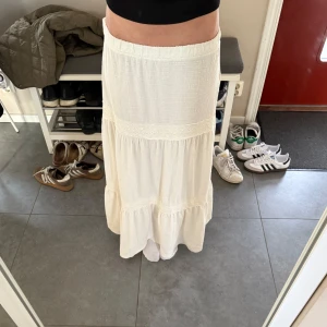 Vit långkjol från Mango - Säljer en vit långkjol med spetsdetaljer. Stolek M från Mango. Är vanligtvis storlek S så den passar perfekt på folk som har stolek S också. 