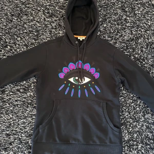 Svart kenzo eye hoodie - En klassisk hoodie som passar med allt möjligt. Kan passa med olika typer av stil som gör tröjan speciellt snygg. Du får den med en garanterad storlek. Den säljs inte för den har en unik gammal modell som inte påverkas nu längre. Passar S Mvh/Sultan