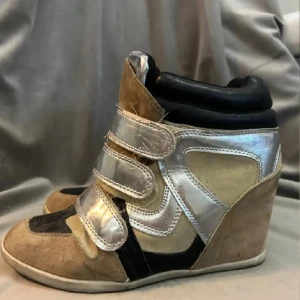 Beige och silver sneakers med kilklack - Säljer ett par Isabel marant liknande skor med kilklack i beige mocka och silverfärgad syntet. 
