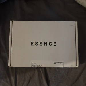 ESSNCE Fleur Chere Eau de Parfum - Parfymen ESSNCE Fleur Chere kommer i en stilren, genomskinlig glasflaska med svart lock. Doften är en Eau de Parfum och levereras i en vit låda med minimalistisk design. Perfekt för dig som gillar eleganta och moderna dofter. Läs om parfymen på deras hemsida. Den är helt oanvänd då jag köpte fel.