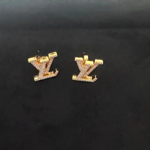 Guldörhängen med strass - Snygga guldörhängen med strass i form av bokstäver. Perfekta för att ge en glittrig touch till din outfit. De är eleganta och passar bra till både vardag och fest.