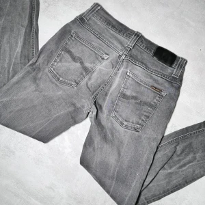 Nudie Jeans - Säljer ett par nudie grim trim jeans. Storlkek 30/34 men passar 30/32. Mörkgrå färg