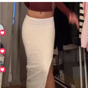 Vit långkjol med slits - Elegant vit långkjol med slits på sidan. Kjolen har en tight passform och är perfekt för en stilren look. Materialet är mjukt och bekvämt, vilket gör den idealisk för både vardag och speciella tillfällen.