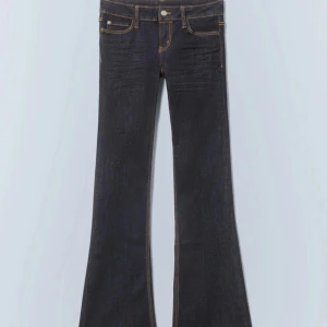 Mörkblå bootcut jeans  - Säljer ett par mörkblå bootcut jeans från Weekday med klassiska gula sömmar och femficksmodell. Jeansen har normal passform upptill och utsvängda ben. Perfekta för dig som gillar retrostil! Nästan helt slutsålda !! 