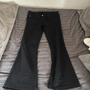 Svarta bootcut jeans från Cheap Monday - Säljer ett par svarta lågmidjade byxor från weekday/cheap monday. Byxorna är i storlek 32/32, väldigt stretchiga. Dom är bootcut och somsagt väldigt lowwaist. Har bara testats inte andvändts därför säljs dom för orginal priset. 