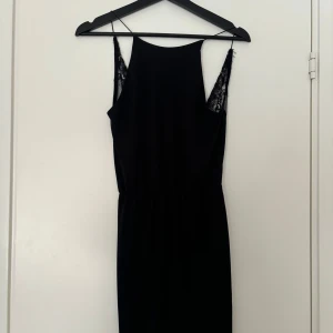 Svart klänning med spetsdetaljer - Säljer min svarta klänning som aldrig har kommit till användning. Den är i storlek Xs, köptes för 250kr säljer för 200kr🩷(32 motsvarar Xs/s!)