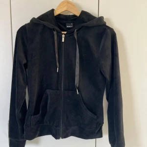 Svart velour hoodie - Mysig svart hoodie i velour från med dragkedja framtill, huva och fickor. Perfekt för en avslappnad stil och sköna dagar. Silkes band i huvan och en figurnära passform, inga tecken på användning. Kan kombineras med byxor i samma set för 250, pris kan diskuteras🥰