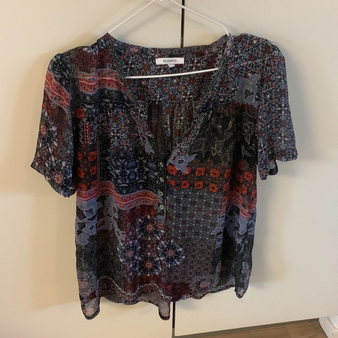 Genomskinlig blus i blått och rött massor med mönster