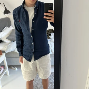 Mörkblå skjorta från Ralph Lauren - Säljer en stilren mörkblå skjorta från Ralph Lauren i slim fit. Skjortan är i linne och fungerar perfekt till sköna sommardagar! Den passar till de mesta och det är bara att höra av er vid frågor!