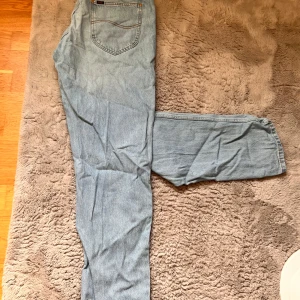 Ljusblå jeans från Lee - Säljer ett par ljusblå jeans från Lee i modellen Oscar. De har en klassisk femficksdesign och en bekväm passform. Perfekta för en avslappnad stil.