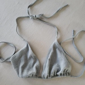Silverfärgad bikini från MKLIFESTYLE - Snygg silverfärgad bikini från MKLIFESTYLE med glittrande yta. Bikinin har knytband i nacken och ryggen för justerbar passform. 