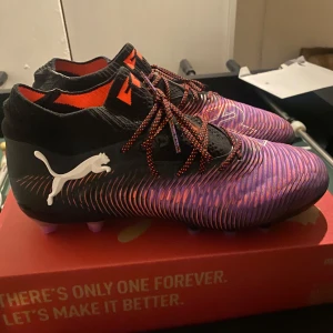 Lila och svarta fotbollsskor från Puma - Säljer ett par puma future elite som är helt nya och aldrig använts på planen, box och påse medföljer även. De är gräs och konstgräs skor så man kan använda på båda. Köpta men passade inte riktigt därav säljs dom. Ingen defekt på dom eller något då dem är helt nya. De är storlek 42 i skon och vid vidare frågor är de bara ställa. Ny pris ligger på 2700