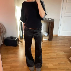Svarta bootcut-byxor i stretchigt material - Säljer ett par svarta bootcut-byxor med låg midja. Super snygga och unika!💙Lånade bilder då byxorna är för stora på mig☺️aldrig använda med prislapp kvar. Midjemått: 82cm                                            Innerben: 85cm