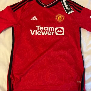 Manchester United hemmatröja 2022/23 - Säljer en röd Manchester United hemmatröja från Adidas. Nytt skick aldrig använd snygg till sommaren . Storlek 164 priset diskuteras