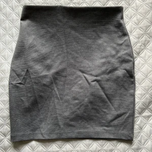 Grå kjol - Snygg grå kjol i en enkel och stilren design. Perfekt för en minimalistisk look. Kjolen har en normal passform och är gjord i ett mjukt material.