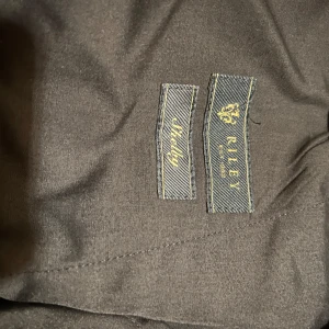 Mörkblå kostymbyxor från Riley - Kostymbyxor från Riley med en klassisk design. Byxorna har en rak passform och är tillverkade av en ullblandning. Perfekta för en stilren look. Mörkblå. Använda endast två gånger så som nya! Nypris 999kr. 