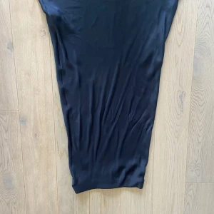 Marinblå satinkjol från Zara XS - Snygg marinblå satinkjol från Zara i storlek XS. Kjolen har en slät och mjuk yta med elegant fall, perfekt för dig som gillar minimalistisk stil. Materialet känns lyxigt och har en lätt glans. Enkel och stilren design utan synliga detaljer.