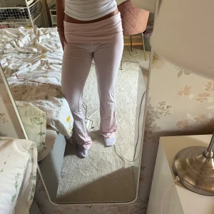 Ljusrosa mjukisbyxor med låg midja - Säljer ett par ljusrosa yoga pants från gina young med låg midja. Lite sönder där nere vid benen 
