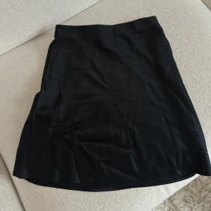 Kortkjol i satin  - Snygg svart kortkjol från Bik Bok i storlek XS, i satin material. Aldrig använd