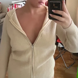 Beige stickad hoodie med dragkedja - Stickad zip som passar både tjejer och killar egentligen. Mjuk och skön. Cashmirliknande material men märke och material okänt.