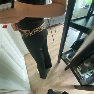 Svarta bootcut byxor - Snygga svarta bootcut byxor med bred midja i leopardmönster. Byxorna har en lågmidjad passform och är tillverkade i ett mjukt, stretchigt material. Vet ej var dem är ifrån!❤️