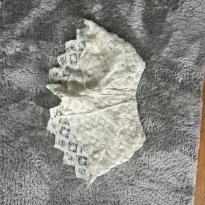 Vita virkade shorts med snörning - Superfina vita virkade shorts med snörning i midjan och snyggt mönstrad spets. De har en loose passform och är perfekta för varma dagar. Detaljerad virkning och scallop-kant ger dem en unik och chill vibe.