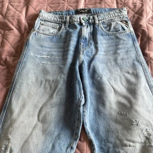 Replay ljusblå jeans med raka ben. Stl: 170 - Säljer ett par ljusblå jeans från Replay med raka ben. Jeansen har snygga slitningar framtill och cool Replay-knapp i midjan. Jeansen är loose fit. Nypris: 550kr 