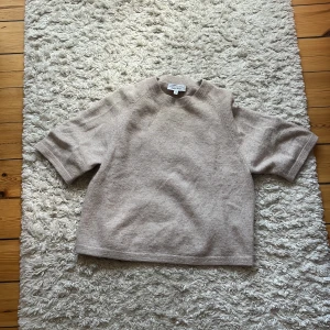 Beige stickad tröja & Other Stories XS - Supermysig beige stickad tröja från & Other Stories. Modellen har korta ärmar, rund hals och loose fit. Perfekt till både jeans och kjol, och den mjuka stickade känslan gör den extra skön. Passar dig som gillar enkel och clean stil.