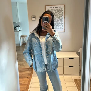 Ljusblå oversized jeansjacka - Säljer en ljusblå jeansjacka med oversized passform och klassisk krage. Jackan har knappar framtill, två bröstfickor och slits på sidorna