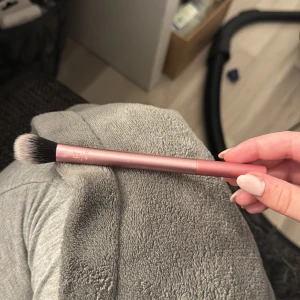 Rosa setting brush från Real Techniques - Säljer en setting brush från Real Techniques med ett snyggt rosa skaft och mjuka syntetiska borst. Perfekt för att applicera puder eller highlighter med precision. Borsten är lätt och smidig att använda för att få till en flawless finish.