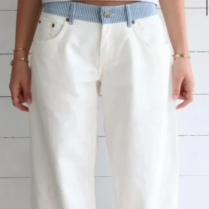 Vita wide kostymbyxor med blårandig midja - Snygga vita kostymbyxor med breda ben och en unik blårandig midja. Klassisk femficksmodell, raka bakfickor och knappstängning framtill. Perfekt för dig som gillar en chill och trendig look med lite extra edge.